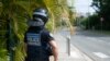 Seorang petugas polisi kota yang dilengkapi dengan flashball berjaga dekat lingkaran lalu melintasi N'Gea, di mana para aktivis berkumpul, di Noumea pada 15 Mei 2024. (Foto: AP)