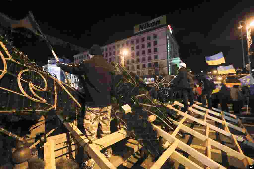 Para demonstran berdiri di depan barikade Alun-Alun Independence di Kiev (2/12).