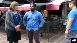 FILE - Christine Hallquist speaks with supporter Asfar Basha in Burlington, Vt.., Aug. 9, 2018. 
