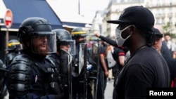 Seorang demonstran berhadapan dengan polisi anti huru-hara dalam unjuk rasa memprotes kebrutalan polisi dan ketidakadilan ras, di Paris, Perancis, 20 Juni 2020. (Foto: Reuters)