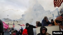 Pristalice predsednika Donalda Trumpa tuku se sa policajcima ispred zgrade Capitola 6. januara 2021. 