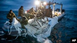 This image provided by the U.S. Navy shows sailors assigned to Explosive Ordnance Disposal Group 2 recovering a high-altitude surveillance balloon off the coast of Myrtle Beach, S.C., Feb. 5, 2023. (U.S. Navy via AP)