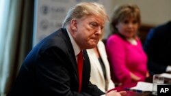 President Donald Trump listens during an event on human trafficking in the Cabinet Room of the White House, Feb. 1, 2019, in Washington. 