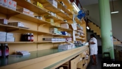 An employee talks on the phone inside a pharmacy in Havana, Dec. 1, 2017. 