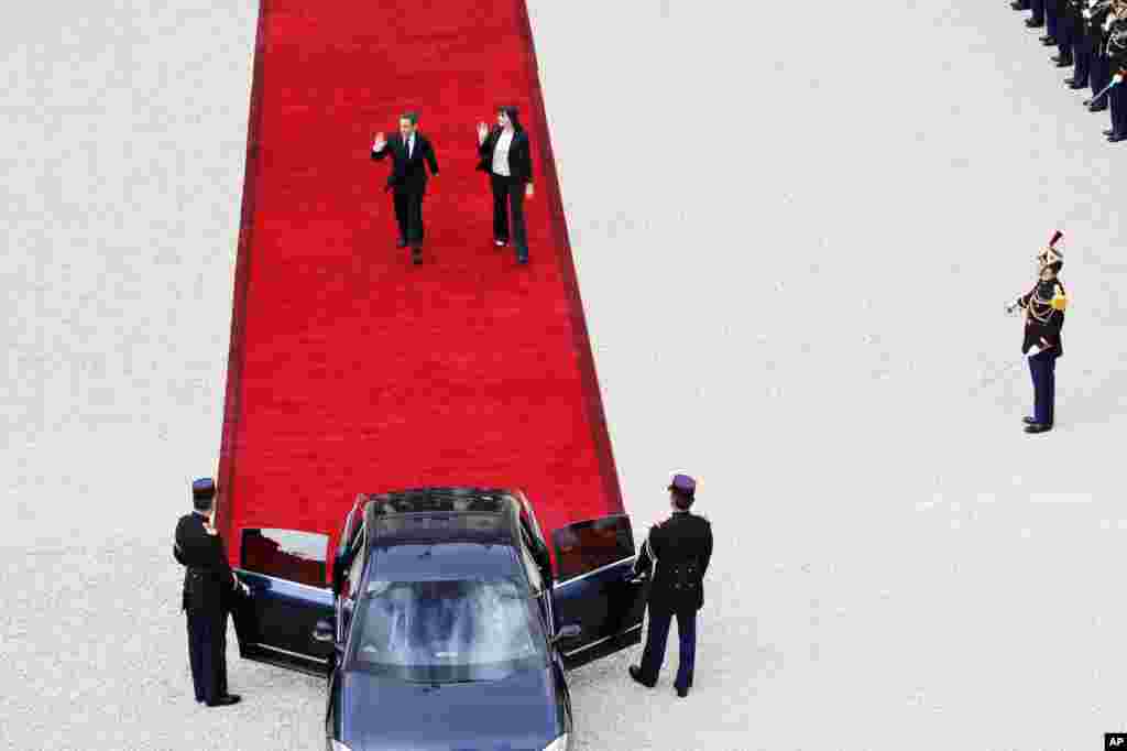 Outgoing French President Nicolas Sarkozy and his wife Carla Bruni-Sarkozy leave the Elysee Palace after the handover ceremony.
