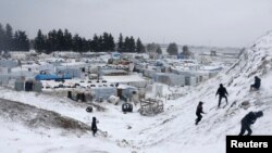 敘利亞難民2013年12月11日在黎巴嫩的難民營玩雪。權益組織說，已經有年幼的孩子被凍死。