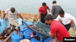 FILE - People carry the body of a Somali refugee, killed in attack by a helicopter while traveling in a vessel off Yemen, at the Red Sea port of Hodeidah, Yemen, March 17, 2017.