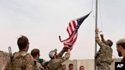 Bendera AS diturunkan dalam upacara serah-terima yang dihadiri tentara AS dan Afghanistan di Kamp Anthonic, Provinsi Helmand, bagian selatan Afghanistan, 2 Mei 2021.