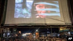 Los espectadores ven desde botes una película proyectada en una pantalla instalada sobre una estructura de madera durante el Festival de Cine Flotante Muyuna, que celebra los bosques tropicales, en el barrio Belén de Iquitos, Perú, el sábado 25 de mayo de 2024