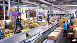 FILE - Image taken from video shows people working inside the UNICEF warehouse, the world's largest humanitarian aid warehouse, in Copenhagen, Denmark , Tuesday Oct. 13, 2020. 