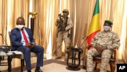 FILE - Kenya's Ambassador to the U.N. Martin Kimani, from Kenya, left, leads a United Nations Security Council mission meeting with Transition President Col. Assimi Goita, right, in Bamako, Mali, Oct. 24, 2021. 