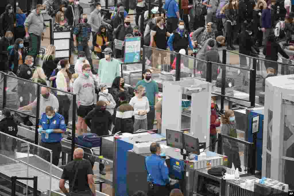 Travelers queue up at the south security checkpoint as traffic increases ahead of the Thanksgiving holiday, Nov. 23, 2021, at Denver International Airport in Denver, Colorado.
