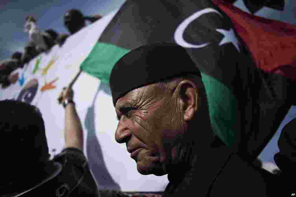 Seorang pria Libya menonton unjuk rasa yang menentang milisi yang berbasis di Tripoli dan mendukung tentara nasional yang baru dan korps polisi di ibukota Libya itu.
