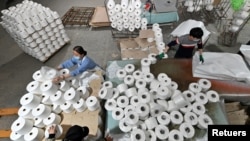 Sejumlah pekerja tampak berada di lini produksi di sebuah pabrik tekstil di Korla, Xinjiang, China, pada 1 April 2021. (Foto: cnsphoto via Reuters)
