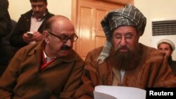 Maulana Sami ul-Haq (kanan), salah seorang juru runding Taliban dan Irfan Siddiqui, perwakilan dari emerintah Pakistan mendiskusikan pernyataan bersama sebelum menggelar konferensi pers di Islamabad, Pakistan, 6 Februari 2014 (Foto: dok).