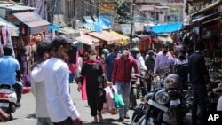 Warga India mengenakan masker saat berbelanja di sebuah pasar di Jammu, India, Minggu, 5 Juli 2020.(AP Photo/Channi Anand).