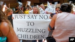 FILE - People celebrate after the Salt Lake County Council voted in Salt Lake City, Utah, to overturn a school mask order for kids under the age of 12 issued by the county’s top health official, Aug. 12, 2021.