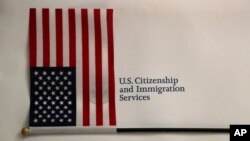 (ARCHIVO) Una bandera estadounidense y un paquete de documentación se muestran antes de una ceremonia de naturalización, el viernes 18 de enero de 2019, en la oficina de campo del Servicio de Ciudadanía e Inmigración de EEUU en Oakland Park, Florida.