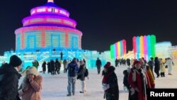 Visitantes toman fotografías cerca de esculturas de hielo en el Festival de Hielo y Nieve de Harbin en Harbin, provincia de Heilongjiang, China, 24 de diciembre de 2023. 