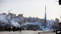 Para pedemo Palestina menyelamatkan diri dari tembakan gas air mata yang ditembakkan oleh para tentara AS dalam demo menentang kebijakan AS tentang permukiman Yahudi, di pos pemeriksaan Beit El dekat Ramallah, kota di Tepi Barat, 26 November 2019.