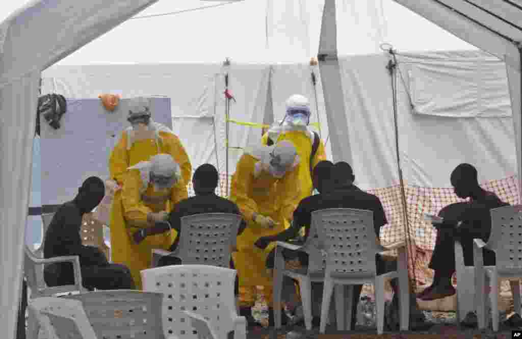 Health workers care for patients infected with the Ebola virus, at a clinic in Monrovia, Liberia, Sept. 8, 2014. 