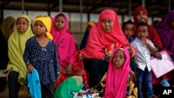 FILE - Somali refugee families wait to be flown to Kismayo in Somalia under a voluntary repatriation program, at the airstrip of Dadaab refugee camp, in northern Kenya, Dec. 19, 2017.