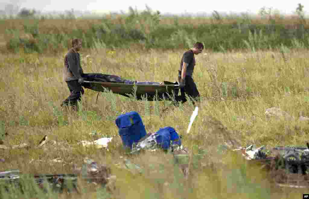 Emergency workers carry the body of a victim at the crash site of Malaysia Airlines Flight 17 near the village of Hrabove, eastern Ukraine, July 19, 2014.
