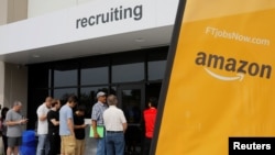 FILE - Job seekers line up to apply during "Amazon Jobs Day," a job fair in Fall River, Massachusetts, Aug. 2, 2017.