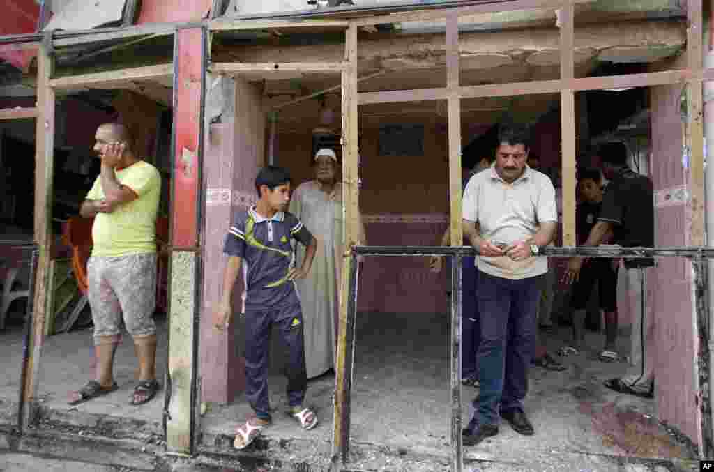 Workers inspect their destroyed restaurant after a car bomb exploded, Baghdad, May 30, 2013.