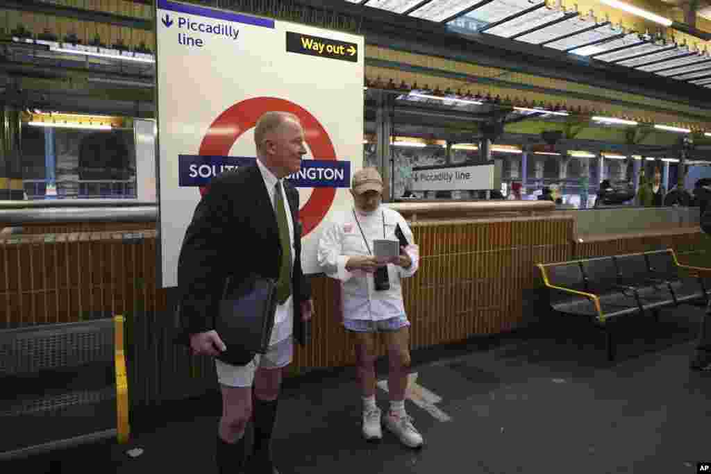 Two men wait for a tube at South Kensington station as they take part in the annual event "No Trousers Tube Ride" in London.