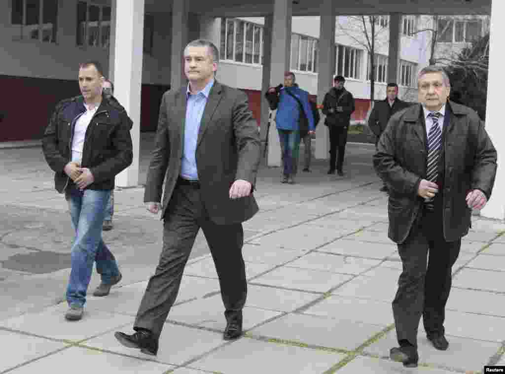 Crimean Prime Minister Sergei Aksyonov (C) leaves after casting his ballot during voting in a referendum at a polling station in Simferopol, Crimea, Ukraine, March 16, 2014.