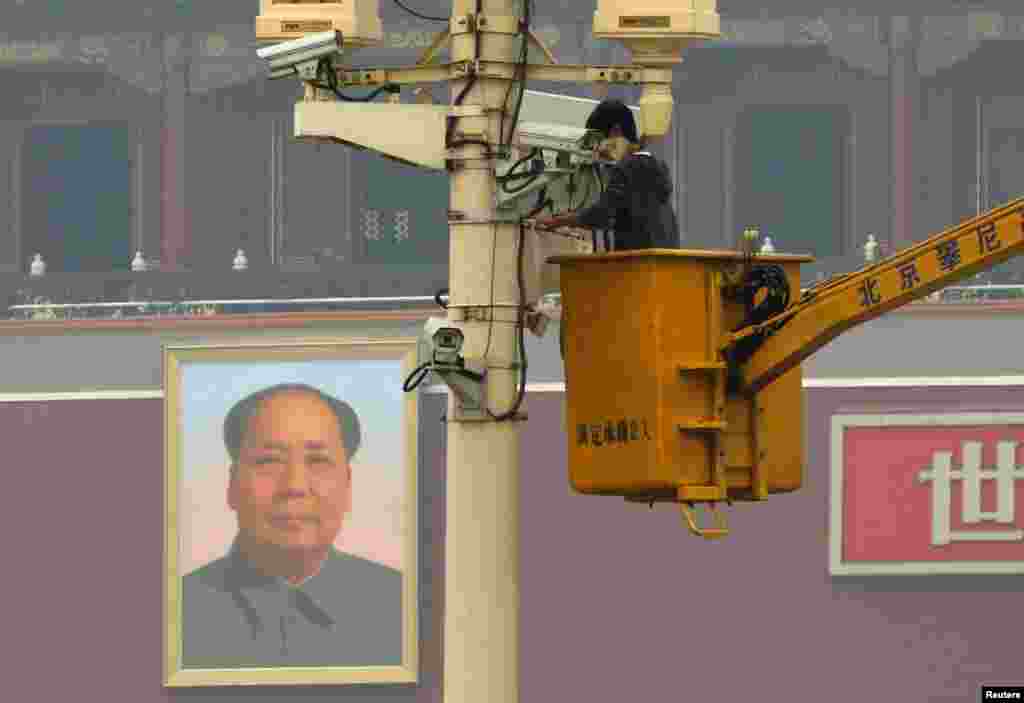 A man installs a security camera at Tiananmen Square in Beijing, Nov. 1, 2013, very close to the site of a fatal vehicle crash in which five people died.