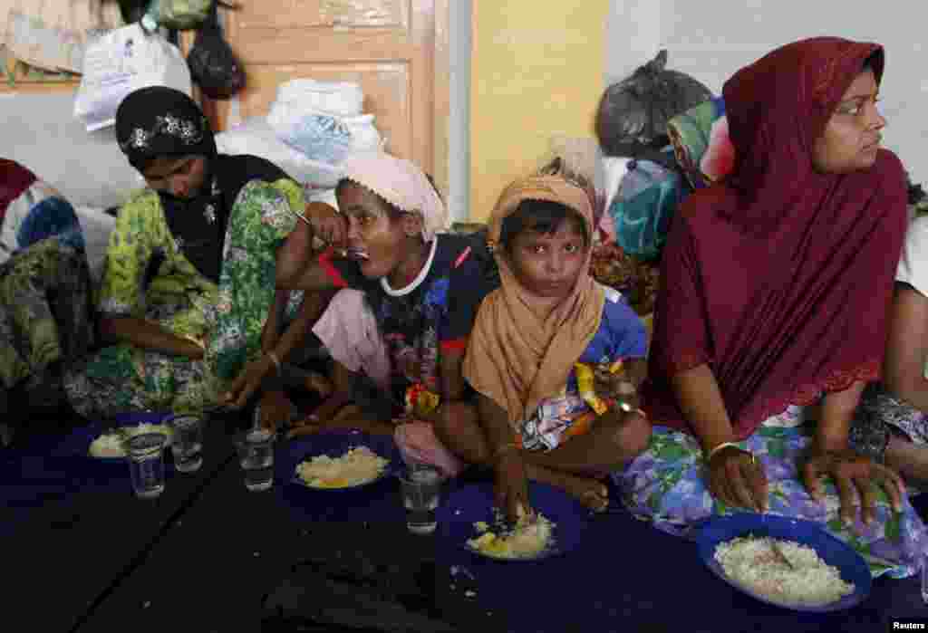 Para migran Rohingya makan sarapan di dalam tempat penampungan di Lhoksukon, Aceh (12/5). (Reuters/Roni Bintang)