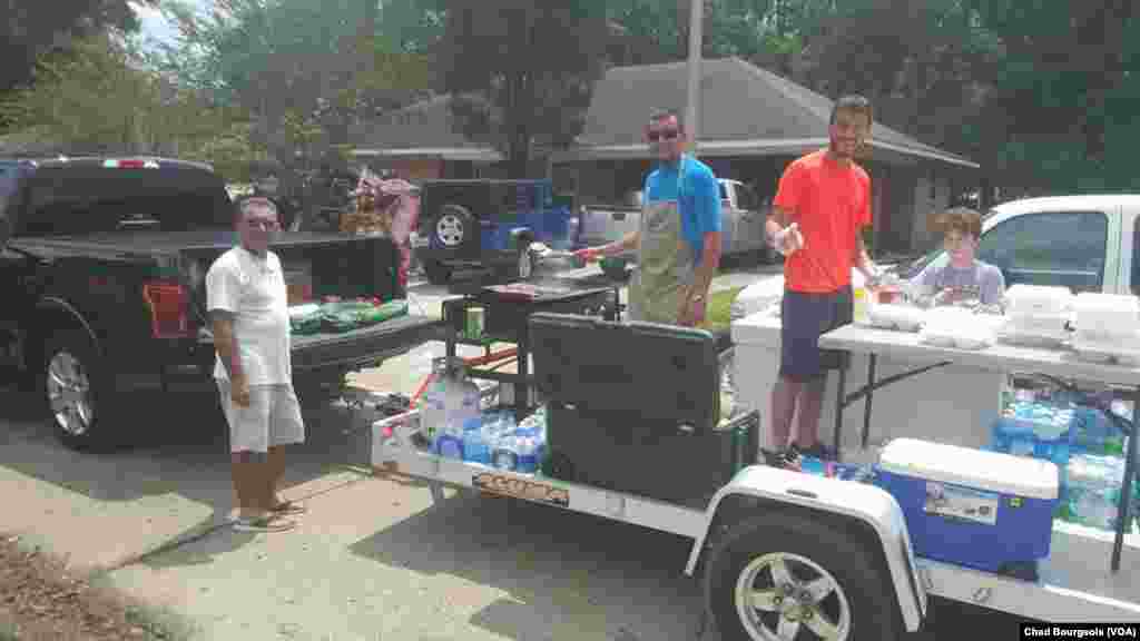 At least one crew of volunteers has been traveling around St. Amant on a trailer with coolers full of food and a working grill, delivering fresh meals.