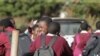 Des écoliers s'embrassent le dernier jour d'école à Harare, au Zimbabwe, le mardi 24 mars 2020. (AP Photo/Tsvangirayi Mukwazhi)