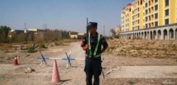 A Chinese police officer takes his position by the road near what is officially called a vocational education center in Yining in Xinjiang Uighur Autonomous Region, China September 4, 2018. Picture taken September 4, 2018.
