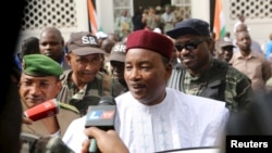 Presiden petahana Niger Mahamadou Issoufou berbicara kepada jurnalis usai memberikan suara dalam pemilu (21/2). (Reuters/Joe Penney)