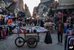 Seorang pria menunggu pelanggan di kiosnya di pasar lokal di kota Qamishli, Suriah utara, yang dikuasai oleh Pasukan Demokratik Suriah yang didukung AS dan dipimpin Kurdi, 28 Januari 2025. (Bernat Armangue/AP)