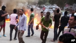 FILE - Supporters of the Muslim Brotherhood set things aflame to block a street during clashes with Egyptian forces following their protest against the government in Cairo's Matariya district, Egypt, June 30, 2015. 