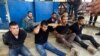Los sospechosos del asesinato del presidente de Haití, Jovenel Moise, sentados en el piso y esposados ​​después de ser detenidos, en la Dirección General de la policía en Puerto Príncipe, el 8 de julio de 2021.