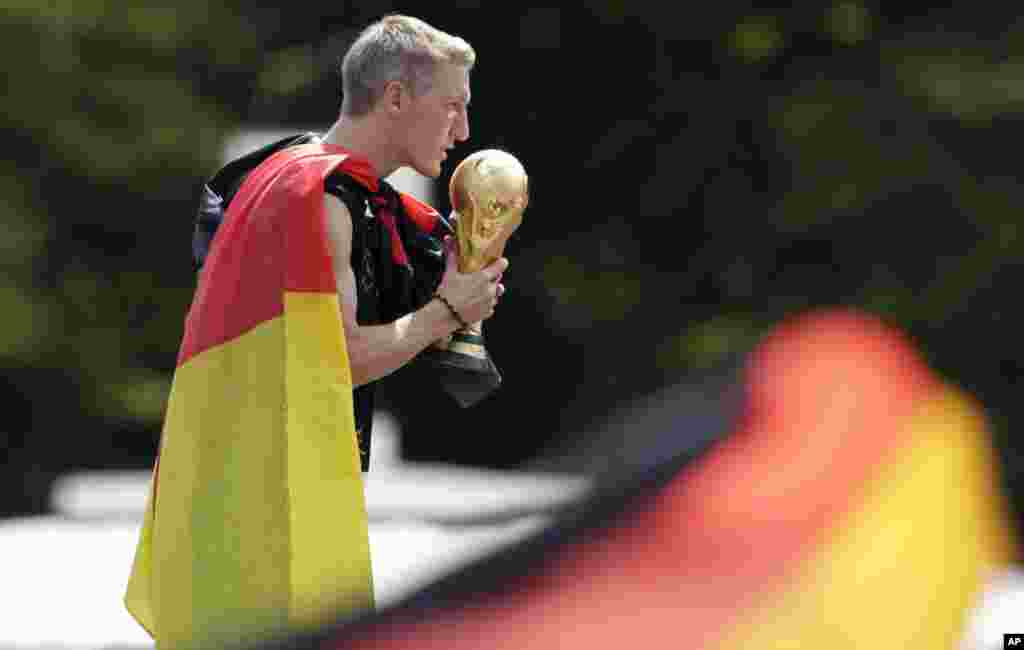 Bastian Schweinsteiger kisses the trophy during the German soccer team's World Cup victory celebration, in Berlin, July 15, 2014.