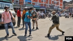 Policemen attack a photojournalist who was covering the Muharram procession in Srinagar on Aug. 17, 2021. (Photo courtesy of Faisal Bashir)