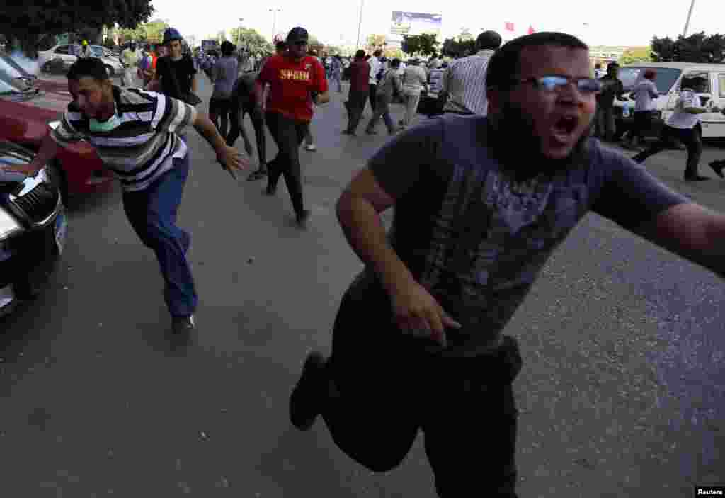 Supports of former Egyptian President Mohamed Morsi run during demonstrations outside the Republican Guard building in Cairo July 5, 2013. 