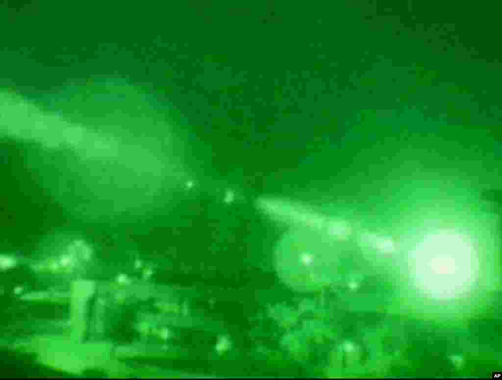Smoke rises moments after the bright light at the right faded during U.S. strikes in downtown Baghdad in this image from television, March 20, 2003.