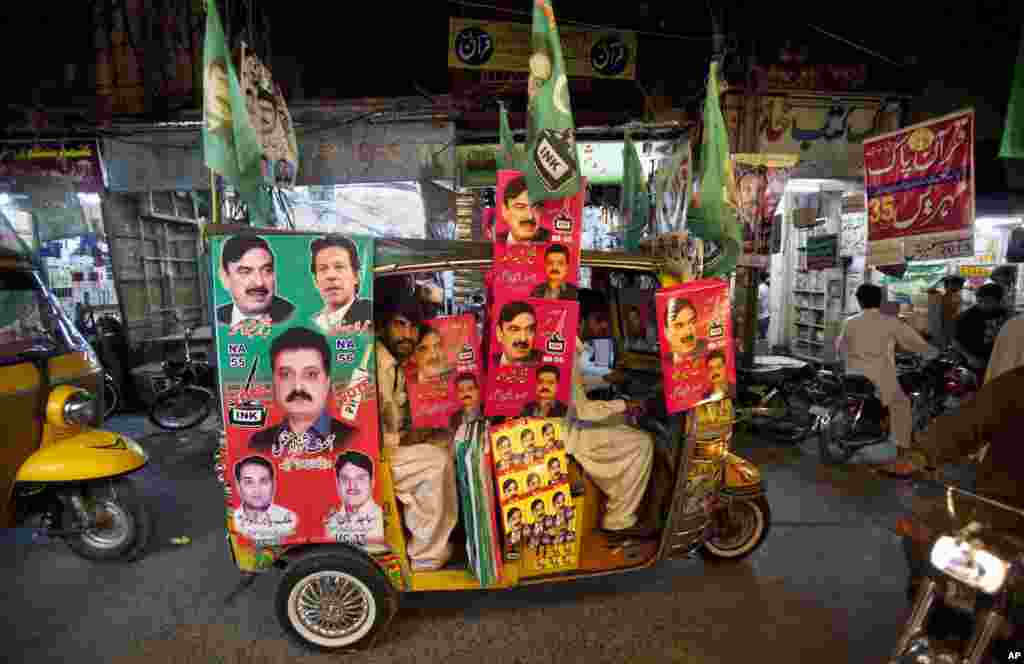 A rickshaw is decorated with campaign posters for candidates in the upcoming election in Rawalpindi, Pakistan, May 8, 2013.