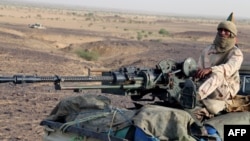 FILE - A Tuareg fighter of the Coordination of Azawad Movements stands on a pickup truck with a machine gun near Kidal, northern Mali, Sept. 28, 2016,