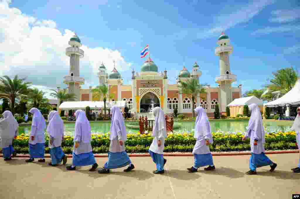 Anak-anak perempuan Muslim Thailand melewati Masjid Pattani sambil menunggu kedatangan Putra Mahkota Thailand, Maha Vajiralongkorn yang berkunjung ke provinsi Narathiwat di Thailand selatan.