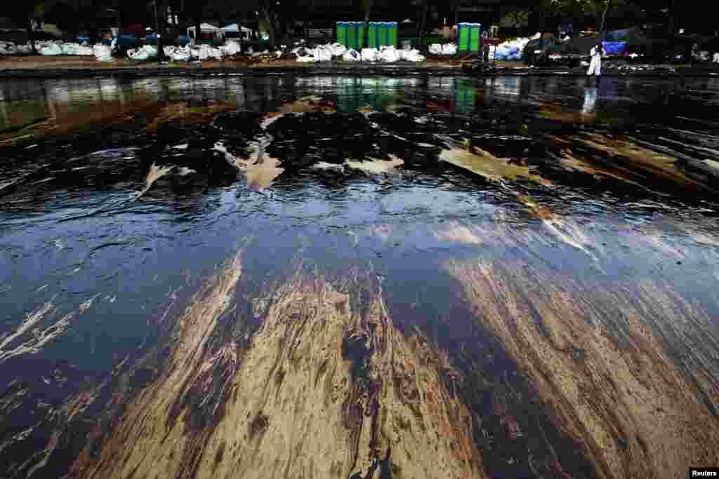 Black oily sludge is seen on sand as cleaning operations continue at Ao Prao Beach on Koh Samet, Rayong, Thailand. An oil spill that has blackened beaches at the holiday island of Koh Samet was having an extreme impact on tourism and could spread to the coast of the mainland and affect the fishing industry, officials and an environmental group said.