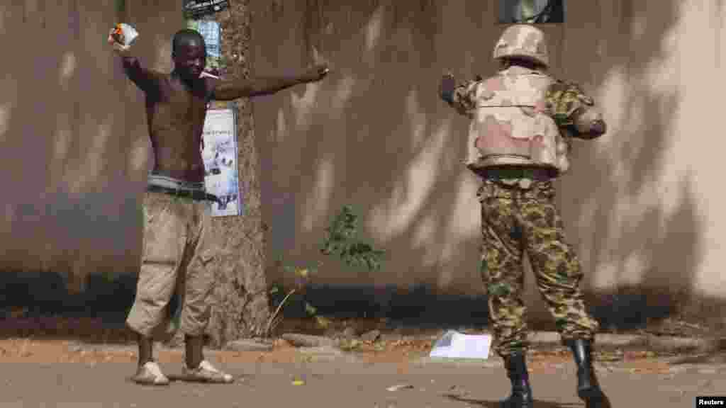 Seorang pemrotes anti-pemerintah berhadapan dengan seorang tentara di depan gedung parlemen di Ouagadougou, ibukota Burkina Faso (30/10).
