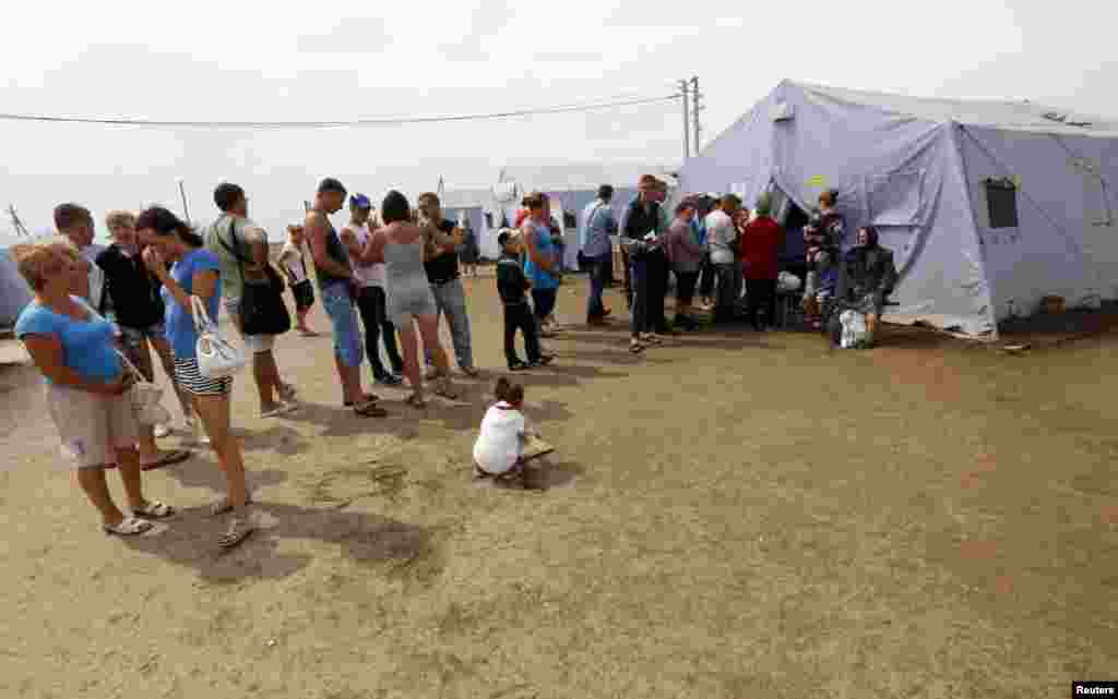 New arrivals stand in a line to register at a refugee camp in Russia's Rostov region, Aug. 18, 2014.